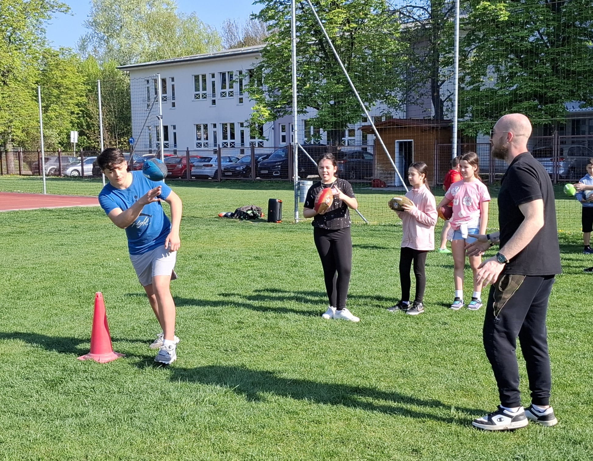 Schüler beim Training einer Wurfübung mit einem ReRe-Sport-Trainer am Sportplatz