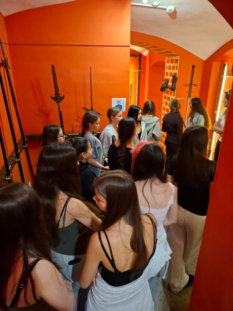 Schülerinnen und Schüler betrachten Hellebarden und Schwerter im Waffensaal des Museums in Ziębice
